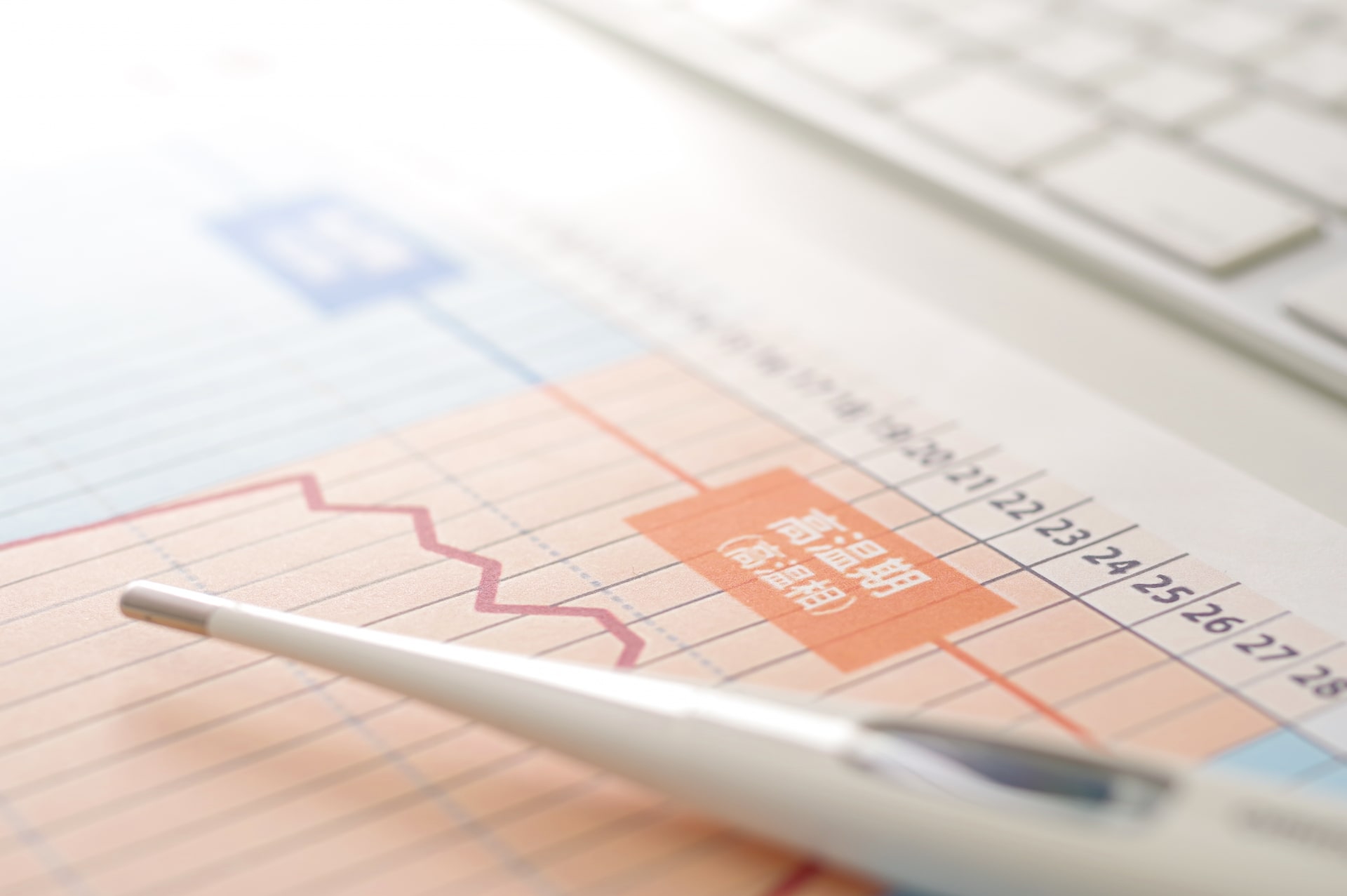 基礎体温の表と体温計の写真画像です。