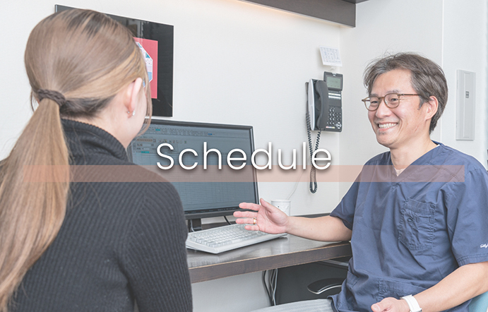 外来担当医表の文字ロゴです。院長と診察を受ける患者さんの写真画像です。