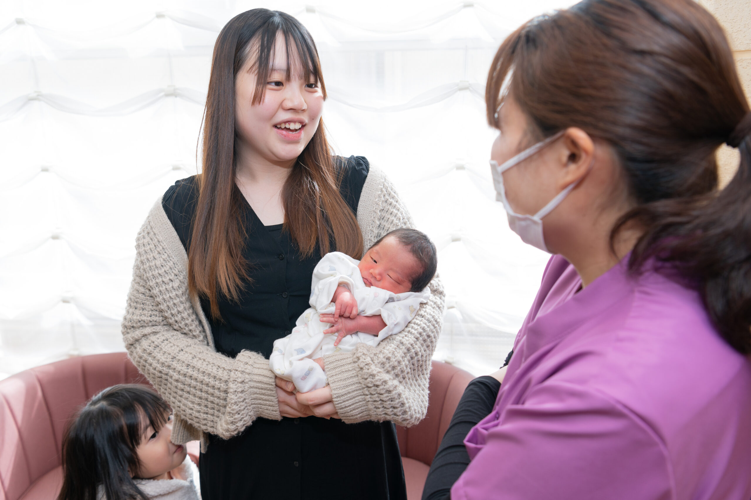 産後検診で青葉レディースクリニックを訪れたママと赤ちゃんと、話をする助産師さんの写真画像です。